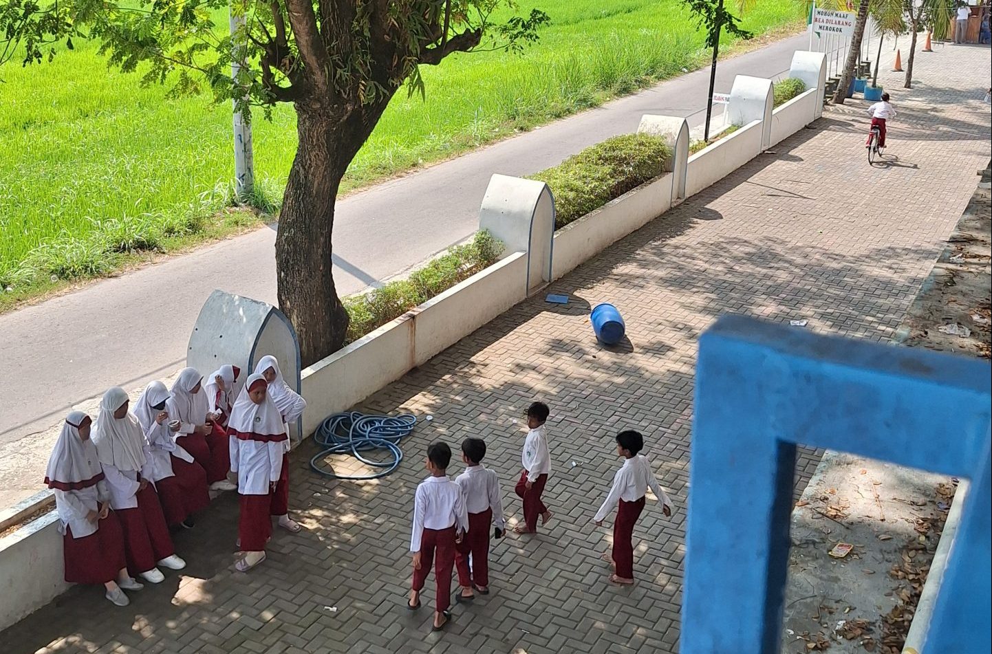 Anak anak berada di sekolah dasar menggunakan seragam dan bermain bersama dengan riang gembira